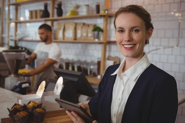 Ejer ved hjælp af tablet med tjener arbejder i cafe - Stock-foto