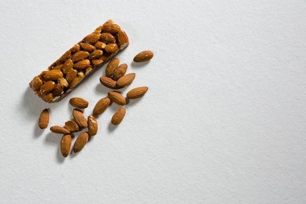 Granola bar and almond on white background — Stock Photo, Image