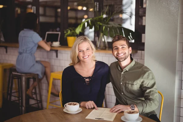 Couple assis avec café et menu — Photo