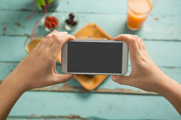 Händerna tar foto av frukost med telefon — Stockfoto