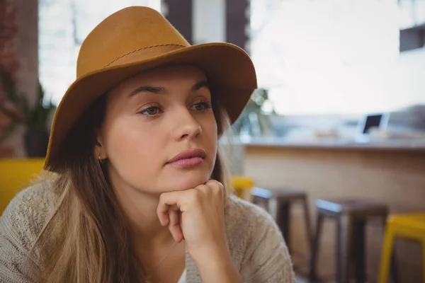 Bedachtzame jonge vrouw die wegkijkt — Stockfoto