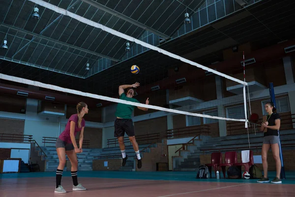 Manliga volleybollspelare med lagkamrat hoppning — Stockfoto