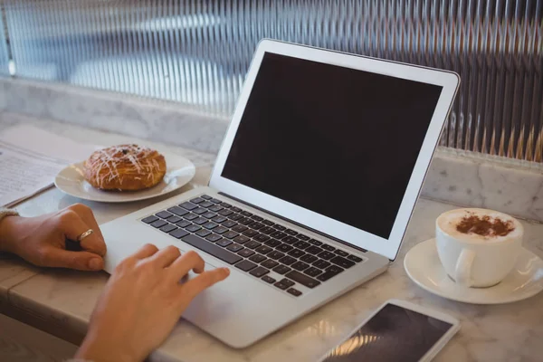 Kobieta korzystająca z laptopa w kawiarni — Zdjęcie stockowe