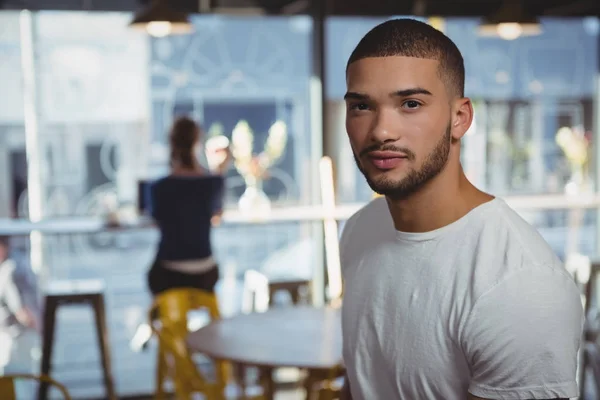 Man met vriend op achtergrond in café — Stockfoto