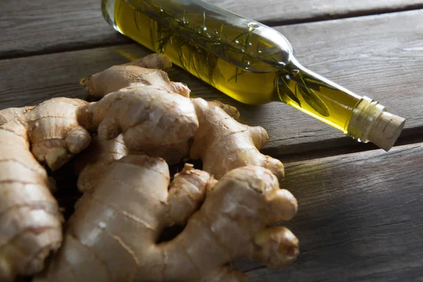 Primo piano di zenzeri con bottiglia di olio — Foto Stock