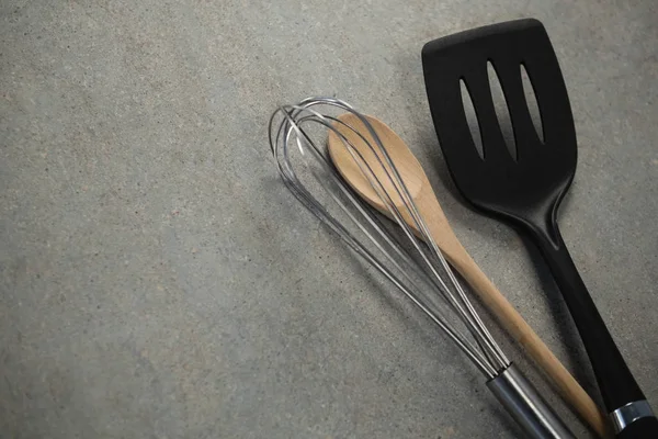 Wire whisk and wooden spoon by spatula — Stock Photo, Image