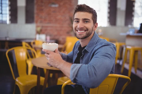 Мужчина держит чашку свежего кофе в кафе — стоковое фото