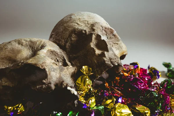 Close-up de crânio com chocolates embrulhados coloridos — Fotografia de Stock