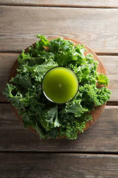 Juice i glas med färsk grönkål på bord — Stockfoto