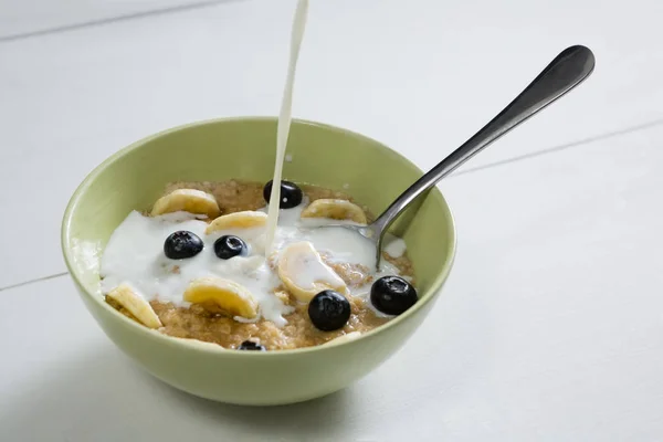 Verter leche en un tazón de cereal para el desayuno —  Fotos de Stock