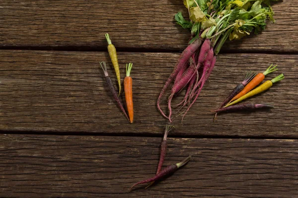Ahşap masa üzerinde çeşitli kök sebzeler — Stok fotoğraf