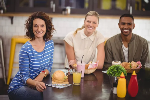 Vrienden zitten met eten en drinken — Stockfoto