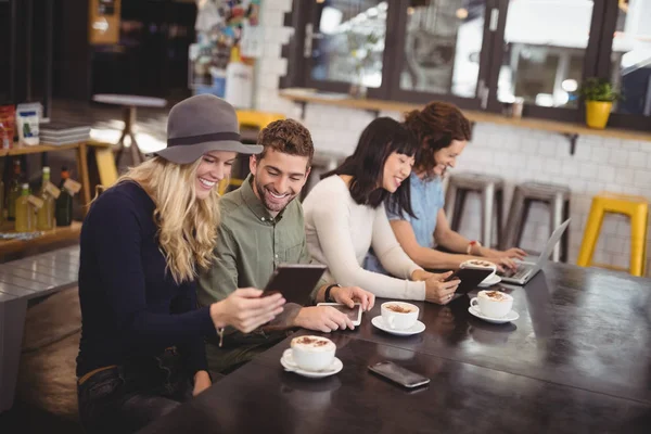 Amici che utilizzano le tecnologie a tavola — Foto Stock