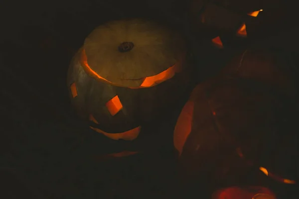 View Illuminated jack o lanterns in darkroom — Stock Photo, Image