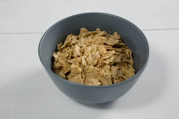 Bowl of wheat flakes — Stock Photo, Image