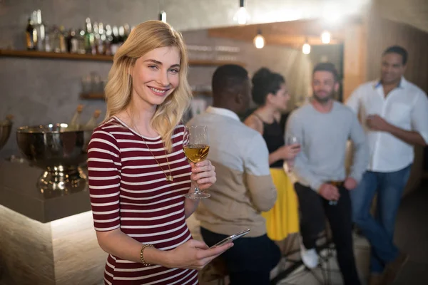 Mujer usando el teléfono mientras toma vino —  Fotos de Stock