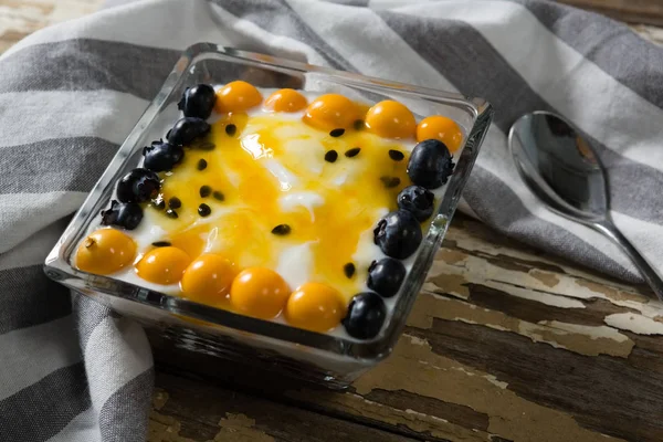 Йогурт с черникой и золотыми ягодами в миске — стоковое фото