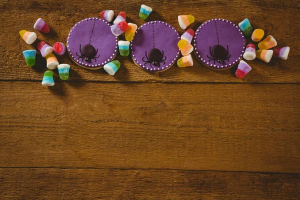 Vista de ángulo alto de las galletas de Halloween con caramelos en la mesa —  Fotos de Stock