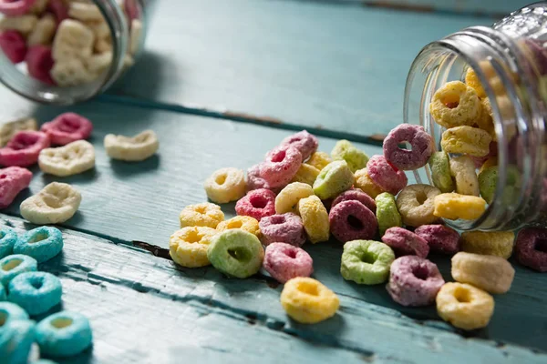 Cereal rings spilling out of bottle — Stock Photo, Image