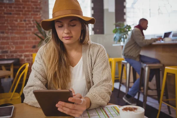 Mujer joven usando la tableta en la cafetería —  Fotos de Stock