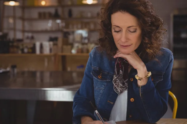 Бізнес-леді, що пише в кафе — стокове фото