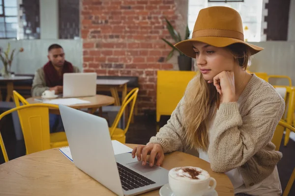 Empresária usando laptop à mesa no café — Fotografia de Stock