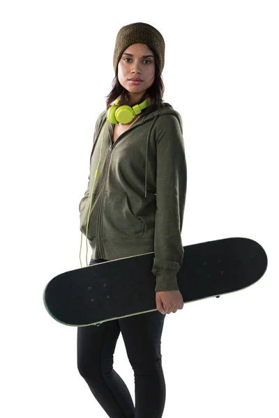 Уверенная молодая женщина со скейтбордом — стоковое фото