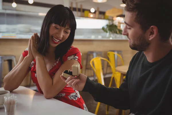Чоловік дає кільце дівчині в кафе — стокове фото