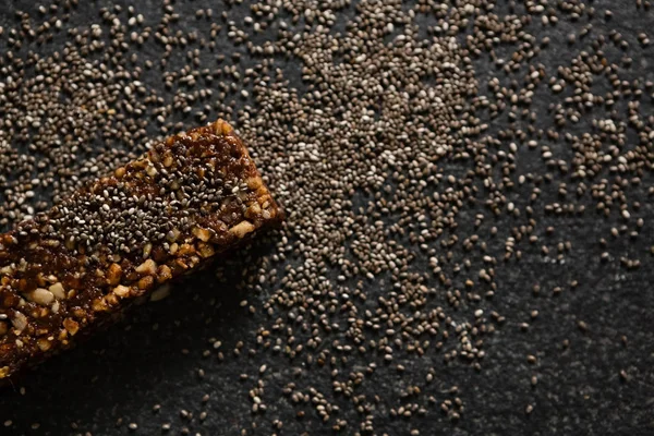 Barra de granola com grãos sobre fundo preto — Fotografia de Stock