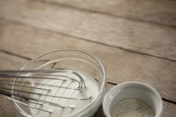 Lait avec fouet métallique et farine en récipient — Photo