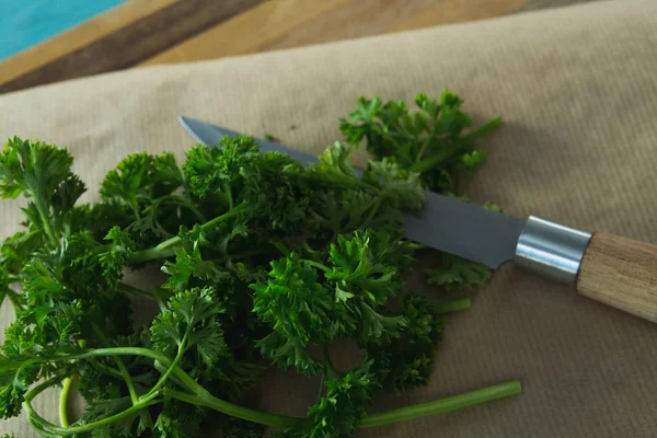 Coriander leaves, wax paper and knife — Stock Photo, Image