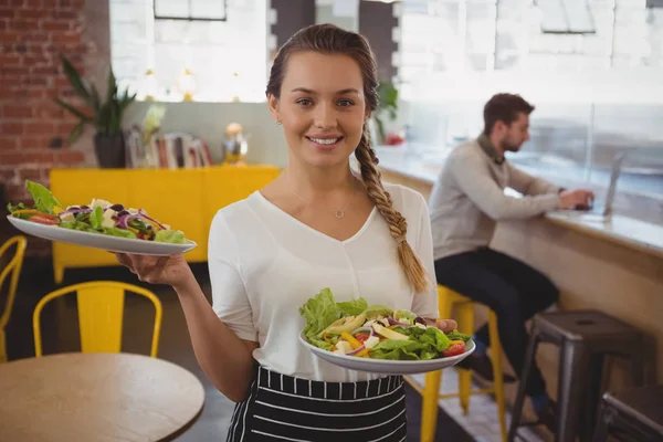 Serveerster bedrijf platen met salade — Stockfoto