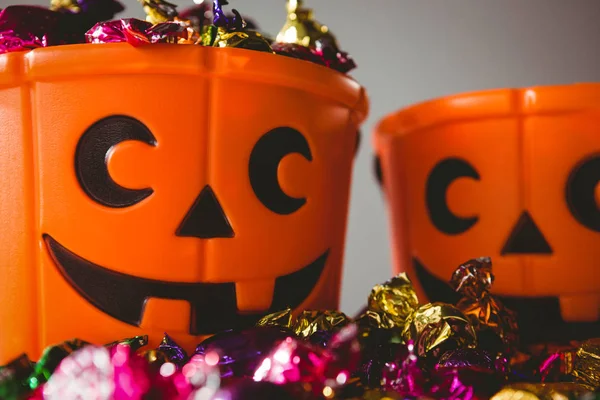 Orange buckets with colorful chocolates Stock Picture