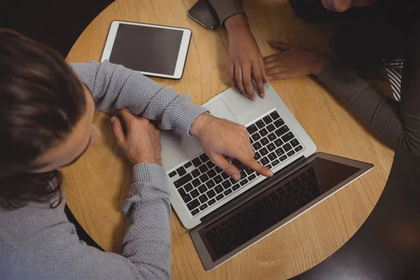 Man met vriend wijzend op laptop — Stockfoto