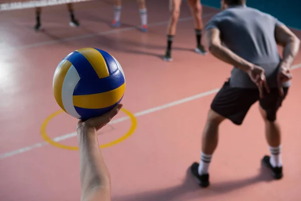 Beskurna handen av spelaren innehar volleyboll — Stockfoto