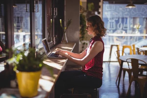 Woman using laptop at coffee shop — Stock Photo, Image