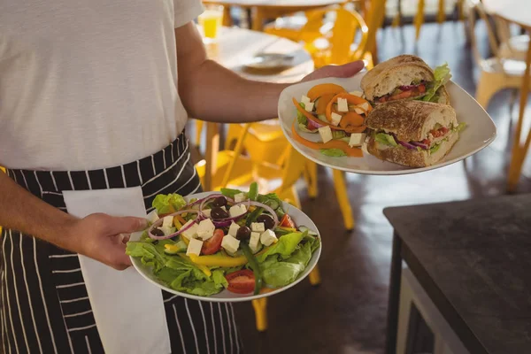 Mitten delen av servitör serverar mat — Stockfoto