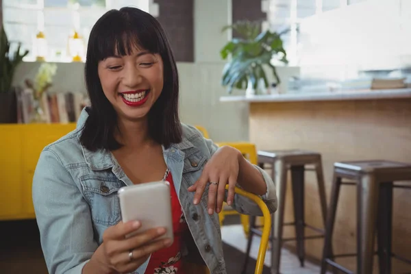 O femeie fericită folosind telefonul la cafenea — Fotografie, imagine de stoc