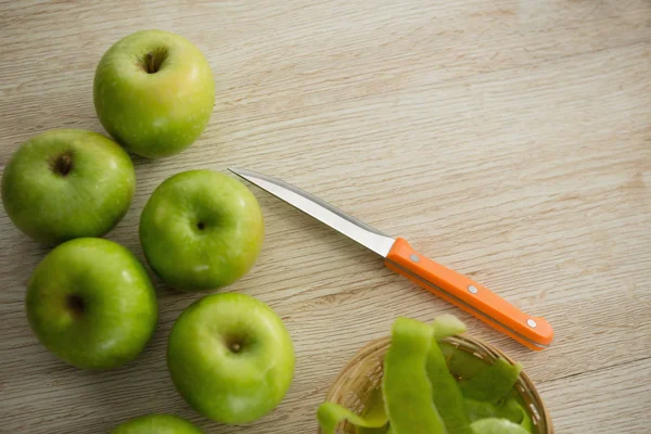 Granny smith jabłka przez nóż skórki i kuchnia — Zdjęcie stockowe