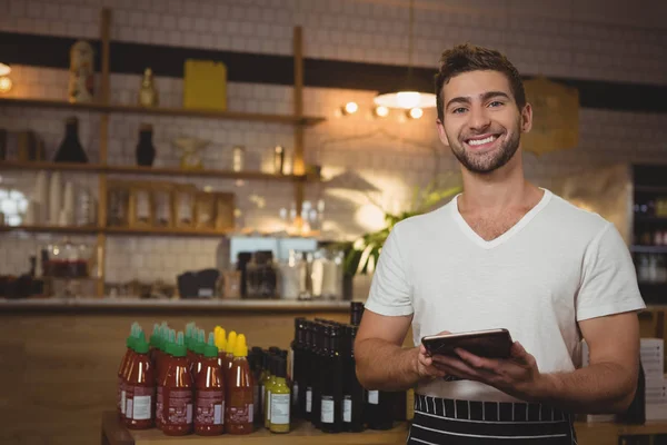 Camarero con tablet digital en la cafetería —  Fotos de Stock