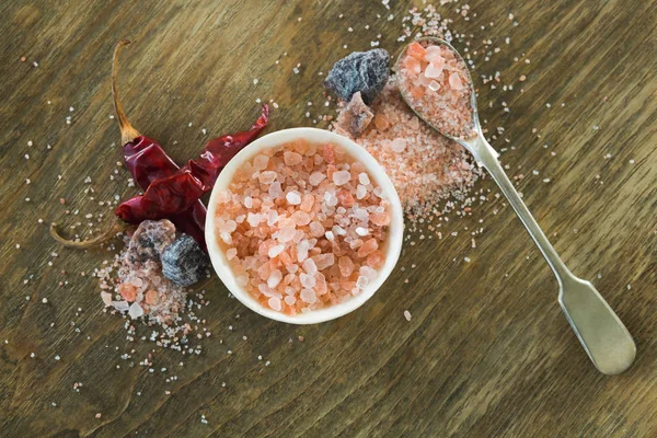 Himalayan salt with spices on wooden table — Stock Photo, Image