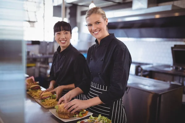 Vrouwelijke chef-koks bereiden van voedsel in keuken — Stockfoto