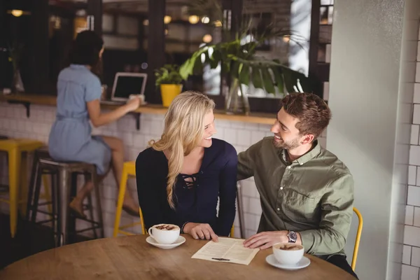 Par som talar medan du sitter med kaffekoppar — Stockfoto