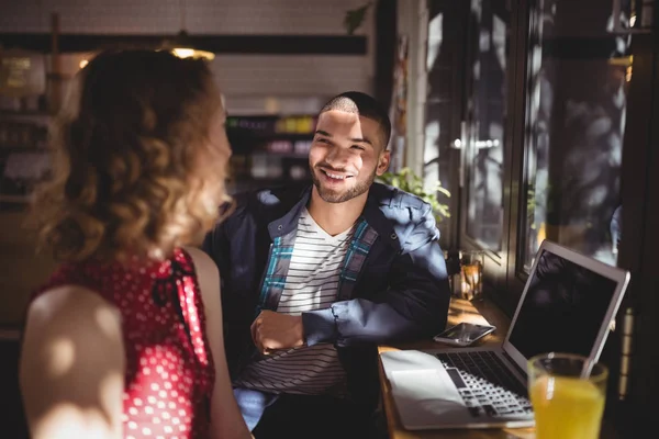 Man talking with female friend at coffee shop — Stock Photo, Image