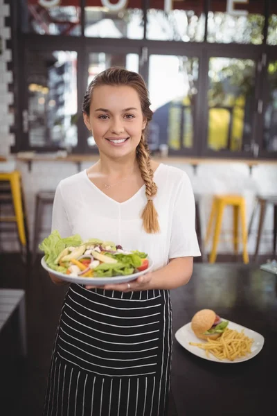 Официантка со свежим греческим салатом — стоковое фото