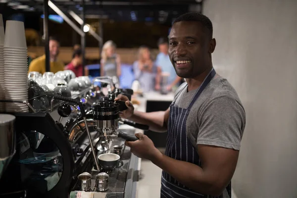 Camarero sonriente haciendo una taza de café — Foto de Stock