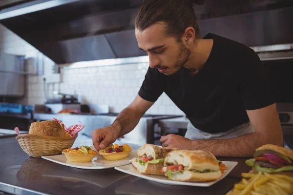 Camarero organizando comida en plato en la cafetería —  Fotos de Stock