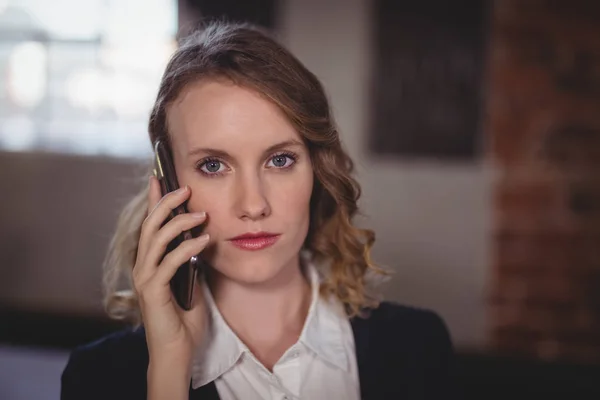 Female editor talking on cellphone — Stock Photo, Image