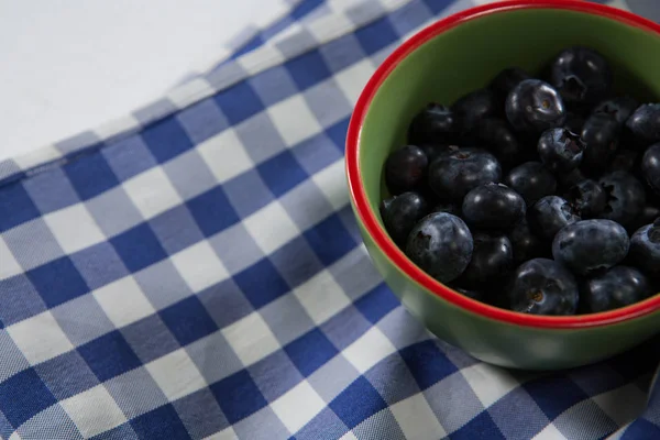 Blueberries in bowl on a textile — Stock Photo, Image