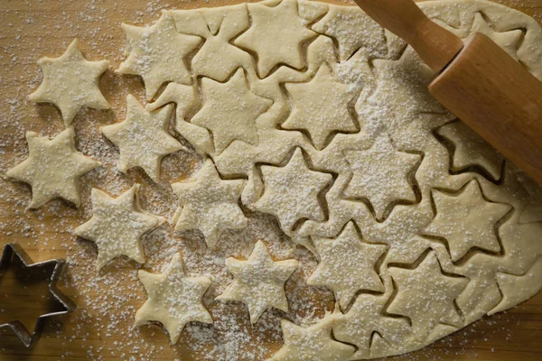Biscoitos de forma de estrela na massa com rolo — Fotografia de Stock